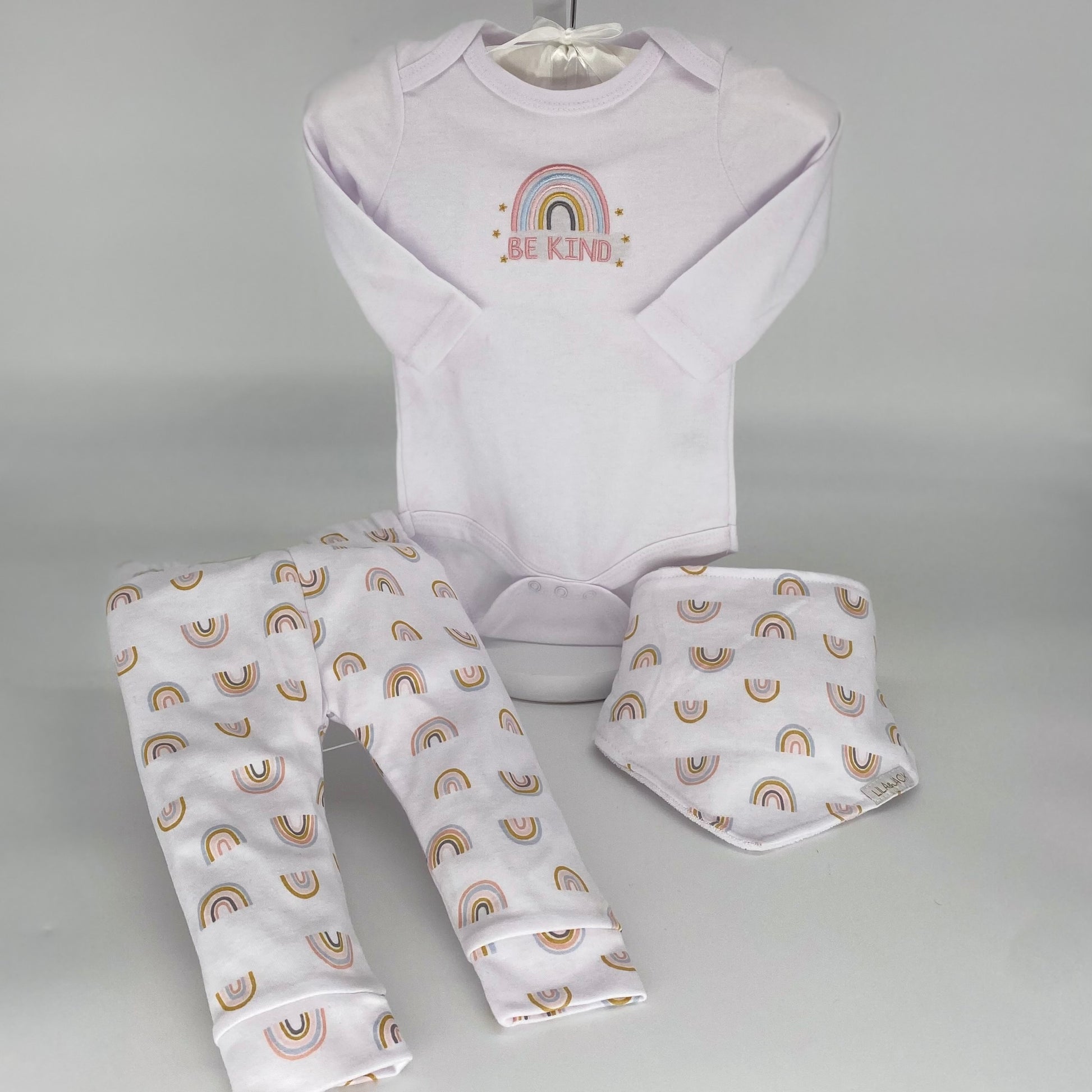 Be Kind Rainbow Collection - sweet 3 piece collection which includes a Be Kind long sleeve onesie, a pair of rainbow pants and coordinating bandana style bib